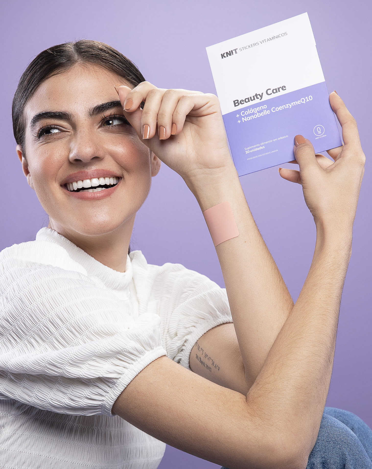 Model holding a Beauty Care KNIT vitamin patch pack against a lilac background