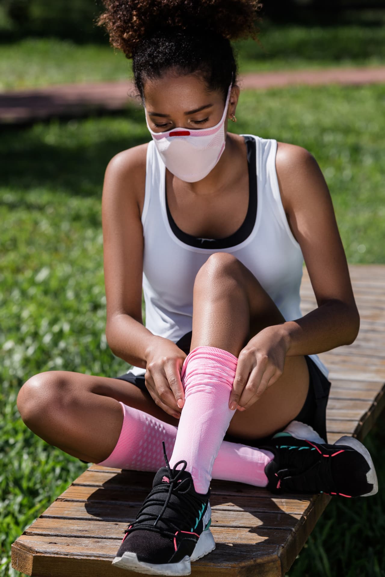 Athlete wearing a white and pink KNIT Fiber Protective Mask outdoors